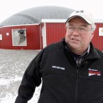James Callaghan and his two brothers run Maryland Farms, a 250 cow dairy operation that set up a biogas operation on their site two years ago. Behind him is the anaerobic digester.