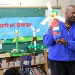 Abasi Sanders shows off one of the creatively designed wind turbines created by students involved in the TREC Education Capture the Wind program in a Toronto school. Photo David Dodge, GreenEnergyFutures.ca