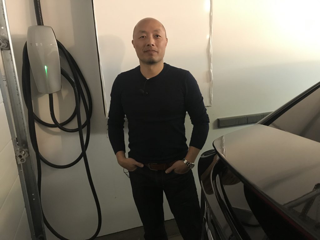 Ed Ma with a Tesla Level II EV charger in his garage. 