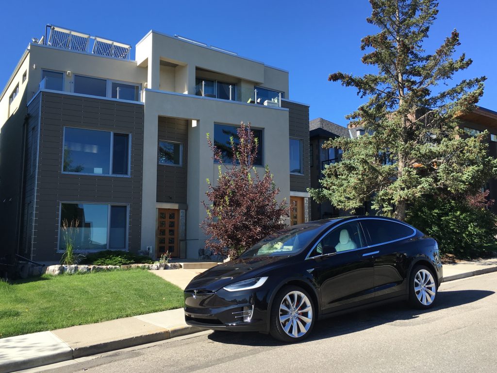 Tesla Model X EV parked in front of Ed Ma's solar thermal home.